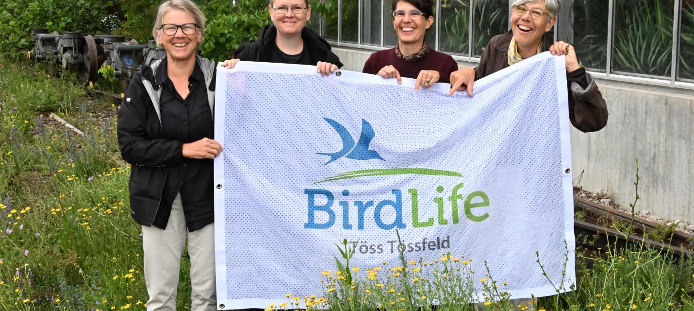 Vorstand in Blumenwiese mit BirdLife-Flagge